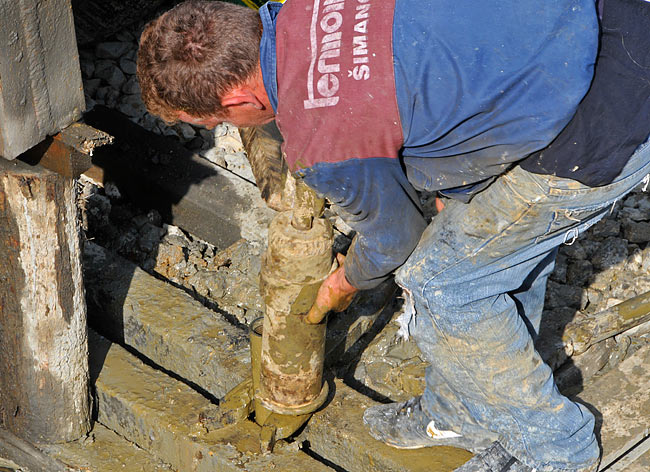 Attaching one drill pipe to the metal part used to pull them up on the derrick