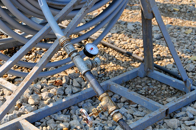 One end of the probe attached to the water supply with the tap and pressure gauge