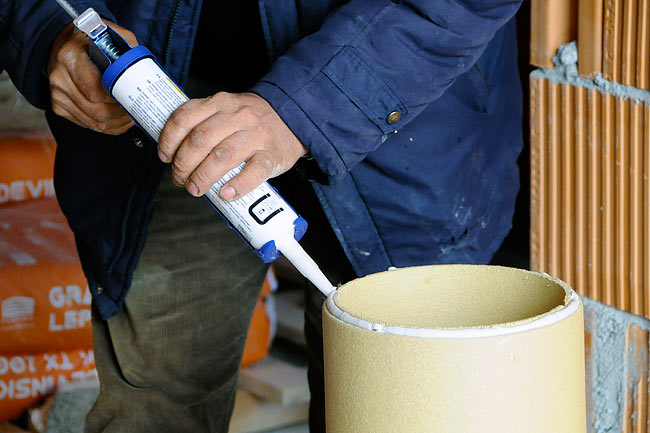 Applying Schiedel joint sealing on the ceramic pipe before stacking it up