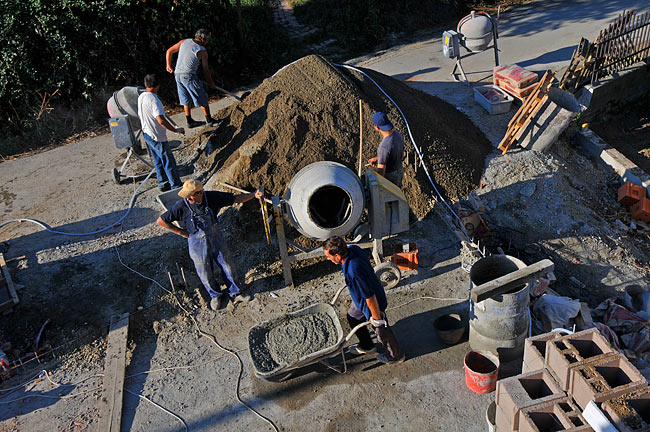 Team of workers preparing concrete on the ground