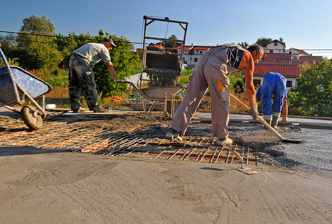 Nasipanje betona iz korpe dizalice u kolica